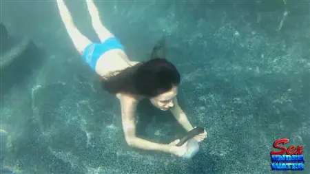 Girl under water licks a rubber dildo