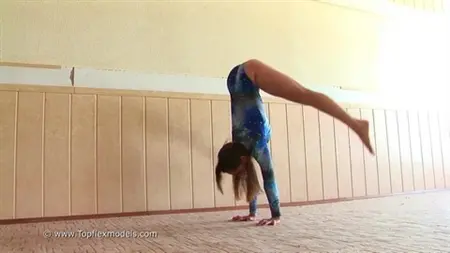 Flexible schoolgirl is engaged in gymnastics on camera