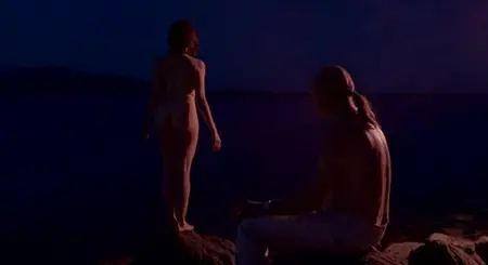 Naked girl stands at night on the lake