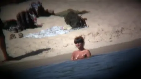 Observe through the camera in the mobile as nudists have fun