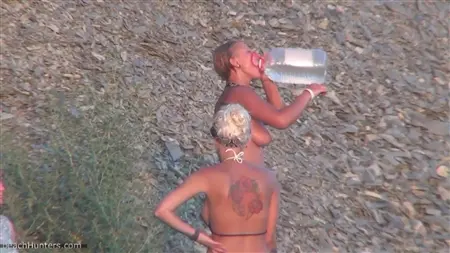 Naked girls wash in a shower on a public beach
