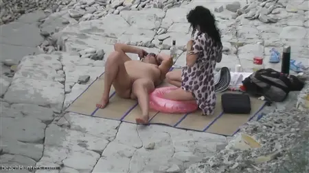 Slutty girlfriends with bare tits relax on a deserted beach