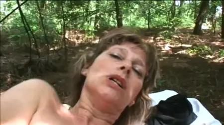 A mature woman in the forest shows her charms and fuck with a man